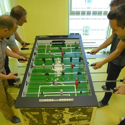 Coworkers playing a game of foosball